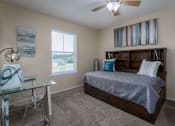Thumbnail 10 of 23 - a bedroom with a bed and a desk with a chair