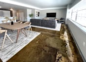 Thumbnail 14 of 19 - A living room with a grey couch and a wooden table.
