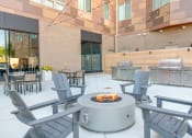 Thumbnail 11 of 31 - a fire pit in the middle of a patio with chairs and tables