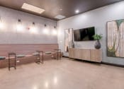 Thumbnail 14 of 31 - a reception area with a tv on the wall and a wooden bench with a vase on