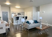 Thumbnail 3 of 19 - A modern living room with a grey couch and a wooden coffee table.