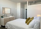 Thumbnail 9 of 19 - A bedroom with a bed, dresser, and mirror.