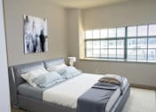 Thumbnail 17 of 19 - A bedroom with a large bed and a painting on the wall.