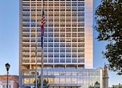 Thumbnail 45 of 60 - an flag in front of a tall building