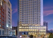 Thumbnail 46 of 61 - a tall building at night with a city in the background