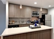 Thumbnail 12 of 17 - Kitchen with quartz countertops and stainless steel appliances