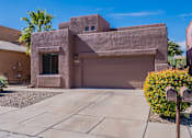 Thumbnail 1 of 9 - A modern house with a concrete exterior and a large driveway.