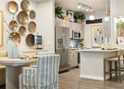 Thumbnail 8 of 11 - A kitchen with a bar area and striped chairs.