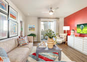 Thumbnail 7 of 11 - A living room with a beige couch, a coffee table, and a ceiling fan.
