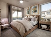 Thumbnail 14 of 22 - A bedroom with a large bed and a ceiling fan.