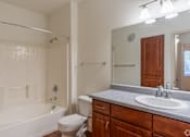 Thumbnail 19 of 24 - A bathroom with a white tub, sink, and toilet.