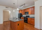 Thumbnail 16 of 24 - A kitchen with wooden cabinets and a granite countertop.