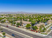 Thumbnail 9 of 24 - A suburban street with cars and houses under a clear blue sky.