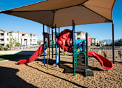 Thumbnail 10 of 22 - A playground with a red slide and a canopy.