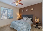 Thumbnail 20 of 24 - A bedroom with a bed, a ceiling fan, and a window with blinds.