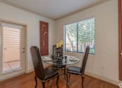 Thumbnail 12 of 24 - A dining room with a table and chairs.