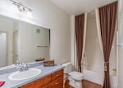 Thumbnail 22 of 24 - A bathroom with brown curtains and a white toilet.