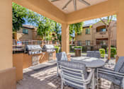 Thumbnail 8 of 24 - A patio with a table and chairs is surrounded by a wall.