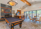Thumbnail 14 of 24 - A pool table is in the middle of a room with a fireplace and a bar.