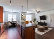Thumbnail 15 of 51 - a kitchen and living room with hardwood floors and a ceiling fan