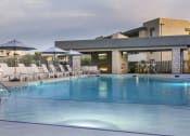 Thumbnail 34 of 39 - a resort style pool with lounge chairs and umbrellas