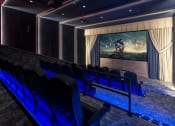 Thumbnail 24 of 39 - a cinema room with chairs and a large screen