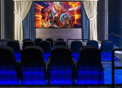 Thumbnail 25 of 39 - a theater with blue chairs and a large movie screen on the wall