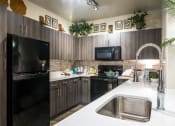 Thumbnail 11 of 39 - a kitchen with black appliances and white countertops