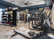 Thumbnail 27 of 39 - a spacious fitness room with cardio equipment and weights