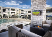 Thumbnail 29 of 39 - an outdoor patio with a fireplace and a pool in the background