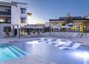 Thumbnail 2 of 51 - a swimming pool with chairs and umbrellas at night