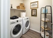 Thumbnail 14 of 51 - a laundry room with a washing machine and a shelf with towels