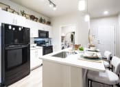 Thumbnail 15 of 51 - a kitchen with black appliances and a white counter top