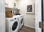 Thumbnail 20 of 51 - a washer and dryer in a laundry room with a white door