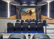 Thumbnail 40 of 51 - a large auditorium with blue chairs and a painting on the wall