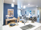 Thumbnail 8 of 51 - a kitchen and living room with blue walls and white counter tops