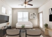 Thumbnail 7 of 51 - a living room with a ceiling fan and a television on the wall