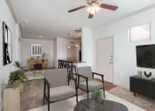Thumbnail 8 of 51 - a living room with a ceiling fan and a table with chairs