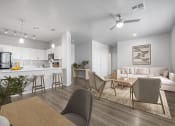 Thumbnail 26 of 51 - a living and dining room with a kitchen in the background and a ceiling fan overhead