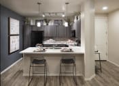 Thumbnail 18 of 23 - an open kitchen with a large island with two stools