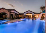 Thumbnail 2 of 23 - a swimming pool with blue lights in front of a resort