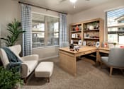 Thumbnail 12 of 34 - A room with a desk, chairs, and a bookshelf.