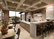 Thumbnail 6 of 34 - A modern kitchen with a bar area and a dining table with chairs.