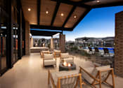 Thumbnail 2 of 34 - A patio with a fire pit and chairs.