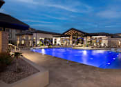 Thumbnail 1 of 34 - A large outdoor swimming pool with a blue light reflection at the bottom.