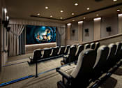 Thumbnail 8 of 34 - A movie theater with rows of seats facing a large screen.