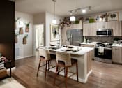 Thumbnail 15 of 34 - A kitchen with a table and chairs in front of a refrigerator.