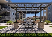 Thumbnail 8 of 56 - A patio with a table and chairs is surrounded by apartment buildings.