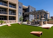 Thumbnail 2 of 56 - A modern building with a patio and a pergola.