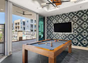 Thumbnail 5 of 56 - A pool table with a green cloth and a television on the wall.